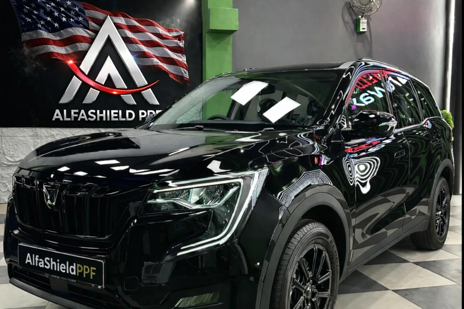 Black SUV with AlfaShieldPPF branding parked in a premium car detailing studio showcasing glossy finish and paint protection film installation
