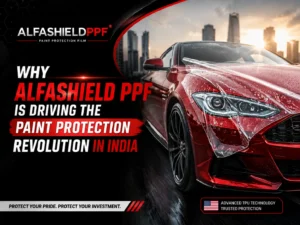 "Promotional banner for AlfaShield PPF featuring a glossy red luxury sports car with a transparent paint protection film being applied to the vehicle's front body. The AlfaShield PPF logo appears prominently in the top-left corner against a black textured background. Bold text reads 'Why AlfaShield PPF is Driving the Paint Protection Revolution in India.' The design uses red, black, and white colors with a modern city skyline in the background, highlighting advanced TPU paint protection technology, vehicle shine, and premium automotive protection."